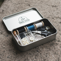 Compact emergency sewing kit in open tin case with needles, thread, buttons, and safety pins