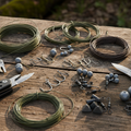 Survival fishing kit with assorted hooks, fishing line, sinkers and tackle on wooden surface
